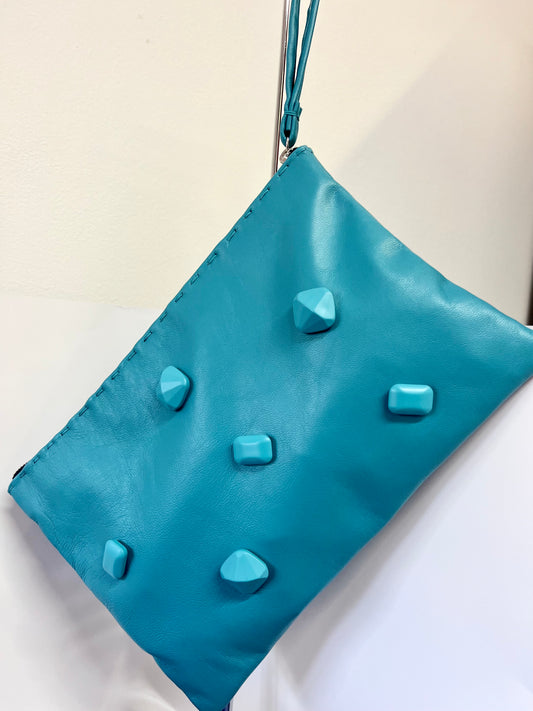 Pochette artigianale in pelle turchese con applicazioni effetto pietra.Turquoise clutch bag in nappa leather with matching stone effect applications.