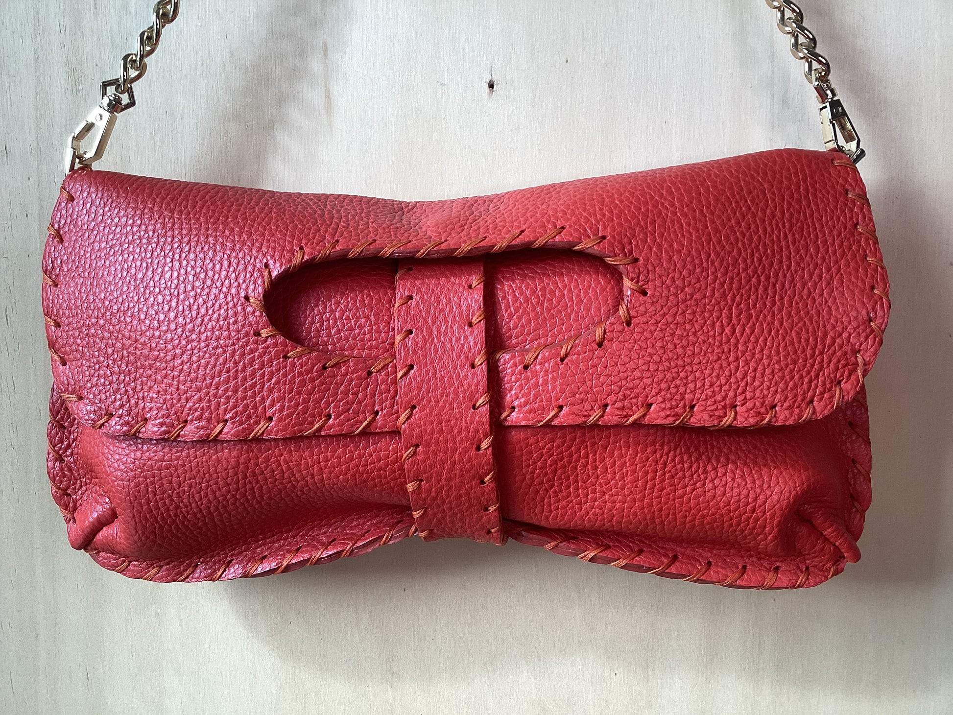 Borsa artigianale in pelle color coccio con chiusura a patta e dettagli di cuciture a mano