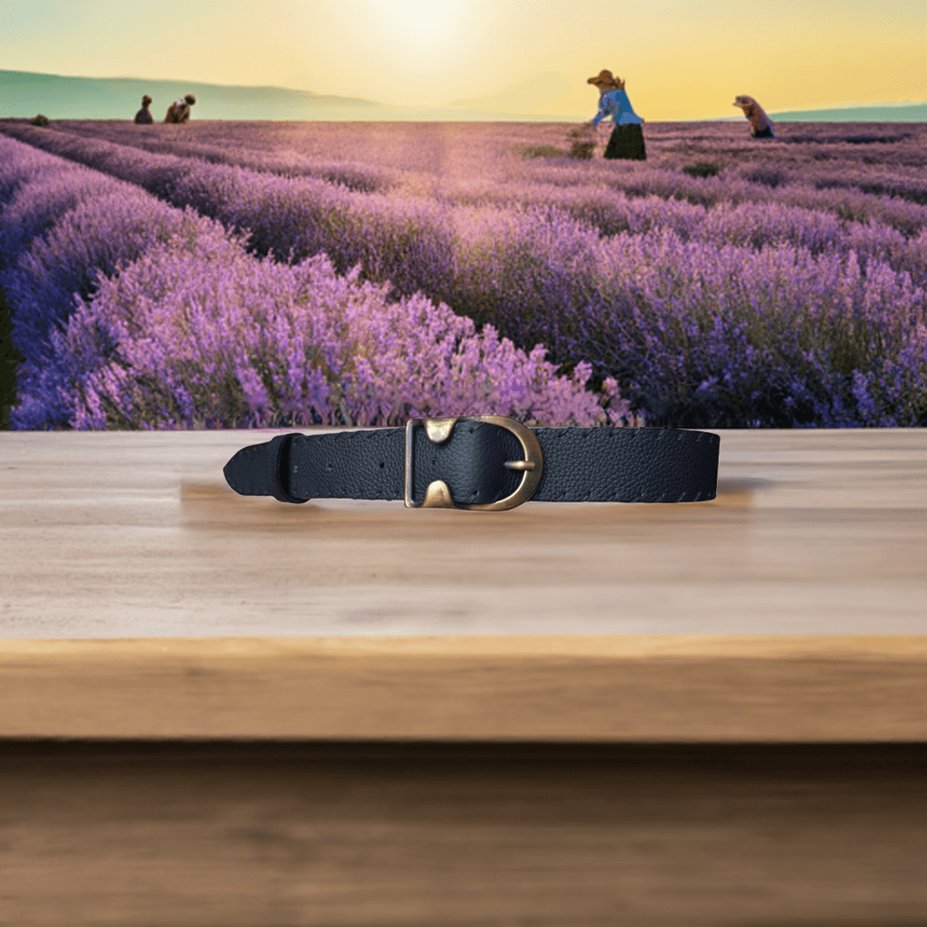 Cintura pelle artigianale nera di Gemelle Toscane con fibbia elegante su sfondo di campo di lavanda
