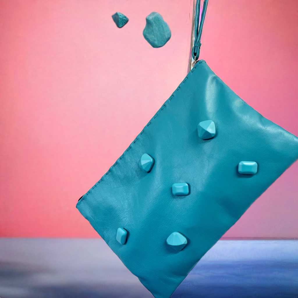 Pochette artigianale in pelle turchese con applicazioni effetto pietra.Turquoise clutch bag in nappa leather with matching stone effect applications.